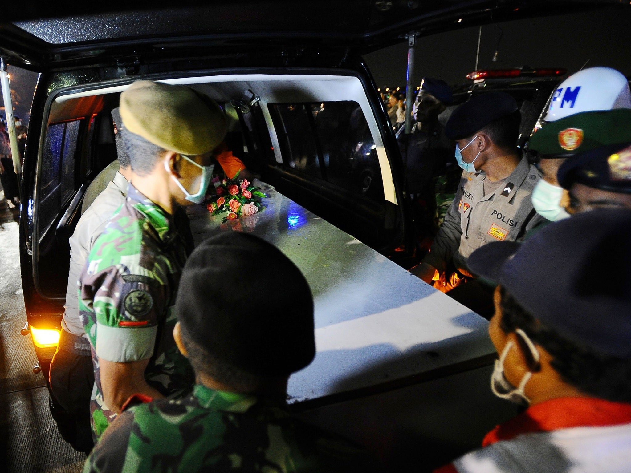 Indonesian soldiers place a coffin containing victims of the AirAsia flight QZ8501 crash in an ambulance to be identified on 4 January, 2015