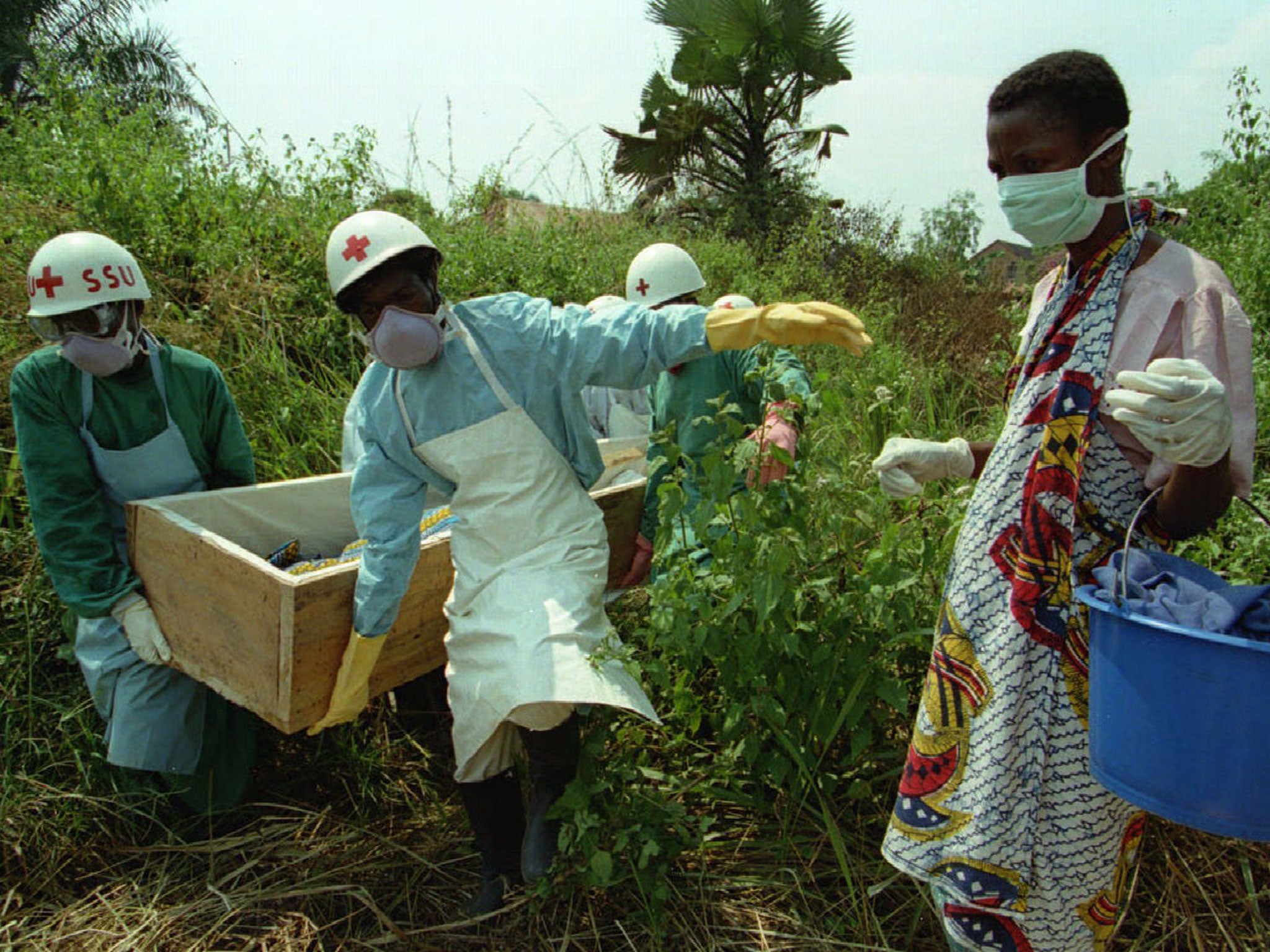 A woman walks beside the body of her mother during the 1995 Kikwit Ebola outbreak in what was then Zaire