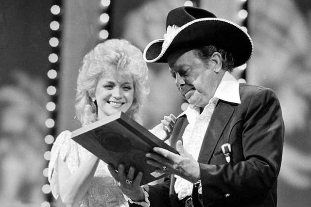 Barbara Mandrell presents Dickens with a plaque marking his induction into the Country Music Hall of Fame in 1983
