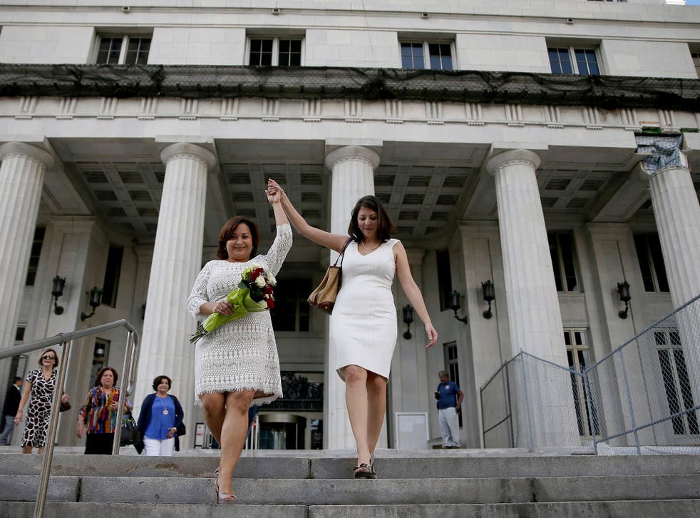 Newlyweds Karla Arguello (L) and Catherina Pareto walk out of the Miami-Dade courthouse as the first couple to marry in Florida after Circuit Judge Sarah Zabel presided over the marriage of the couple during a ceremony in the judges courtroom on January 5