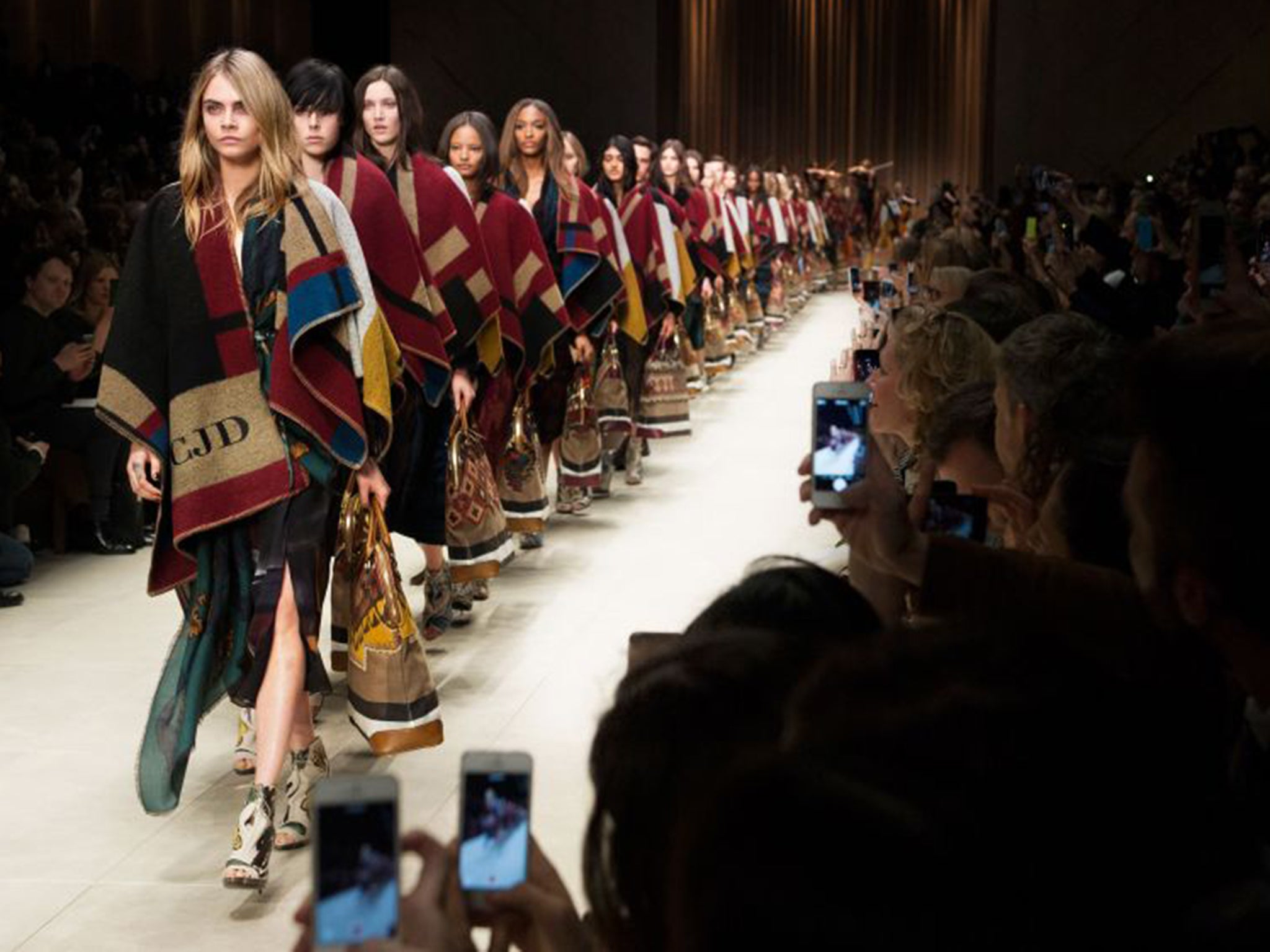 Cara Delevingne sports a monogramed blanket in the A/W 15 Burberry Prorsum show