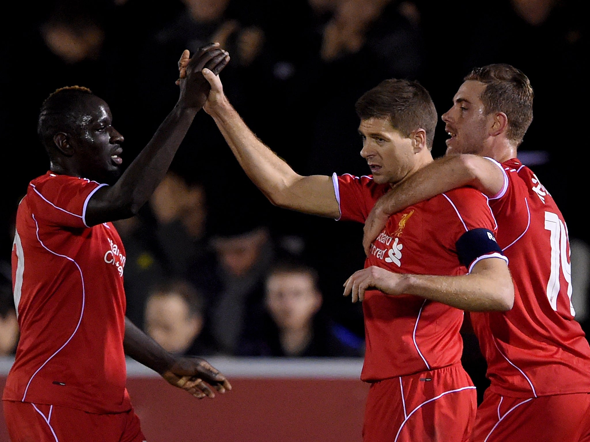 Steven Gerrard is congratulated by teammates Mamadou Sakho, left and Jordan Henderson, right, after scoring Liverpool's second goal from a free kick (Getty)
