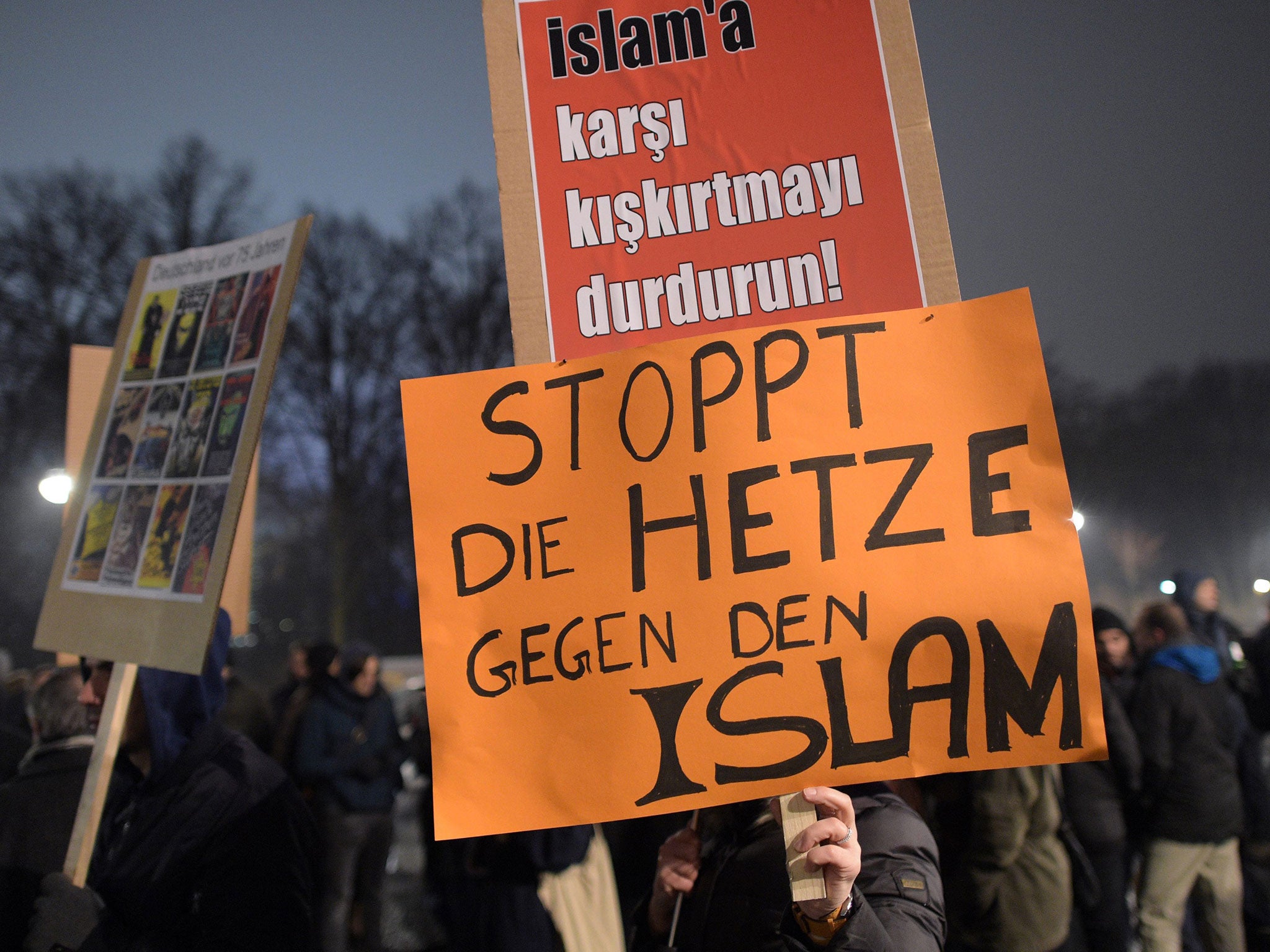 People protest against right-wing initiative Pegida with a sign reading 'Stop agitation against Islam' in Berlin