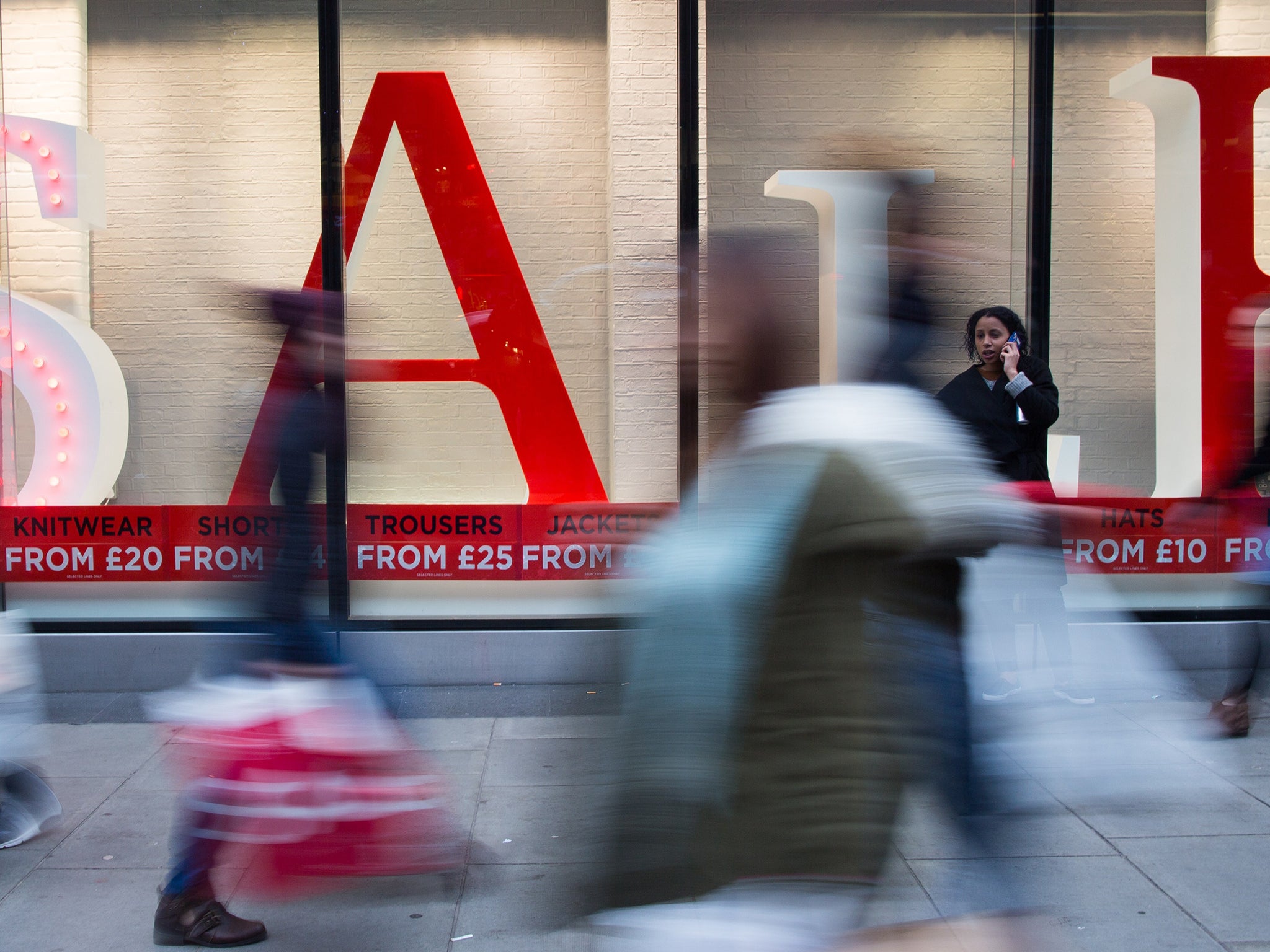 Shoppers walk along Oxford Street to find bargains in central London, on December 26, 2014.