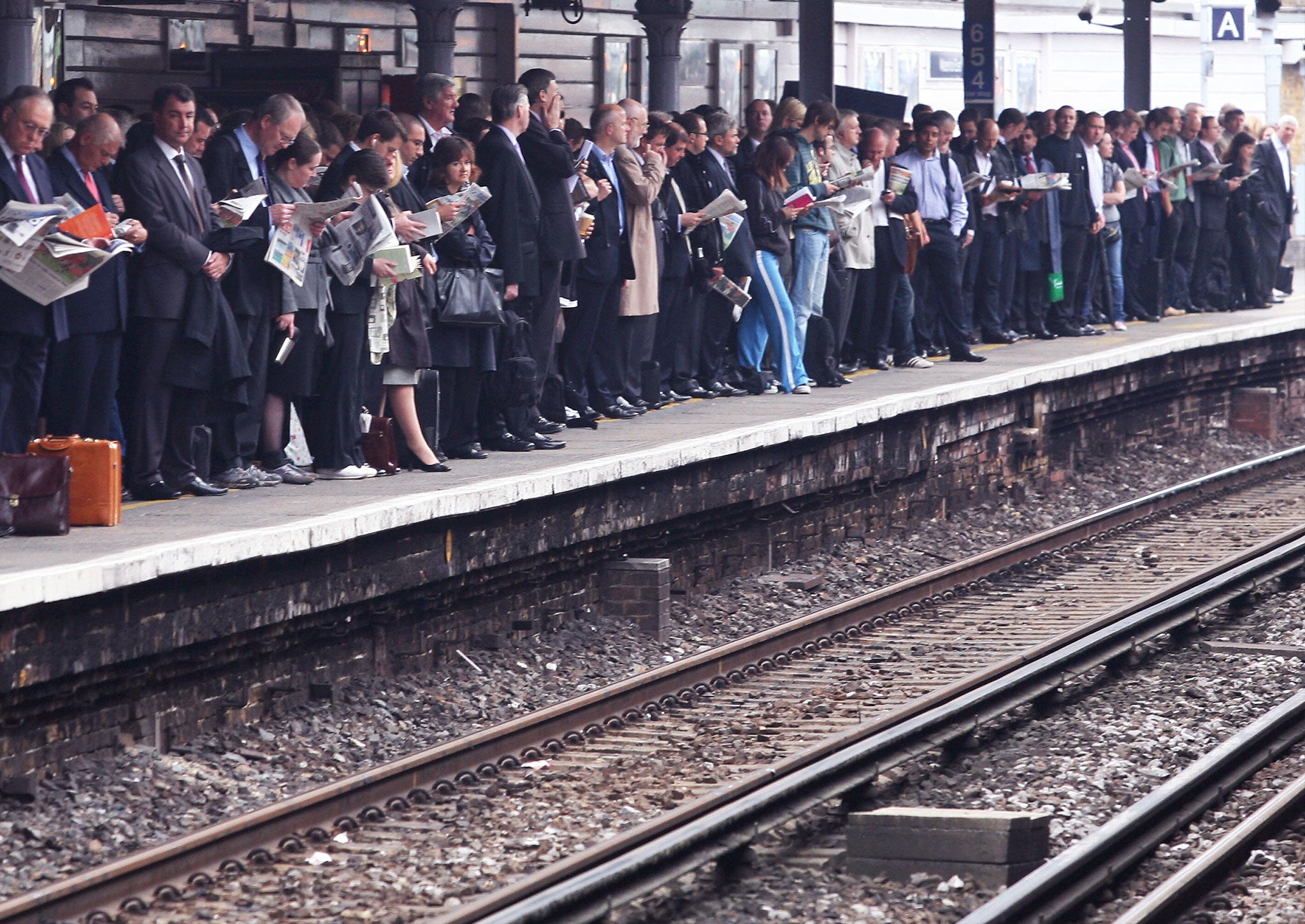 Commuters wait for their train