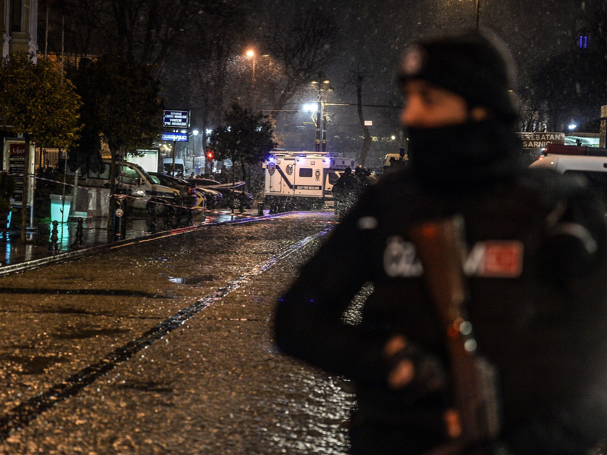A police officer stands guard along a street leading to a police station where a suicide bomb attack took place on January 6, 2015
