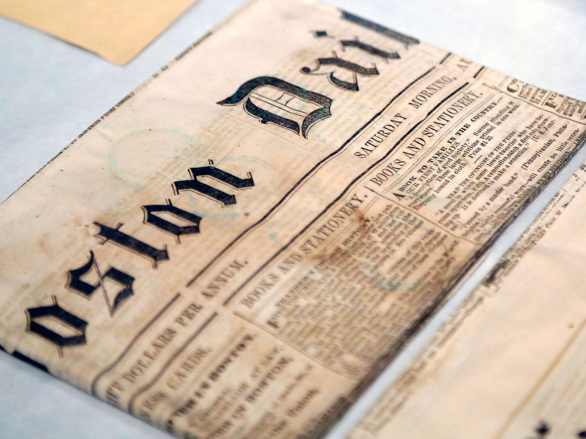Newspapers removed from a time capsule, which was placed under a cornerstone of the State House in 1795, sit in archival boxes at the Museum of Fine Arts in Boston