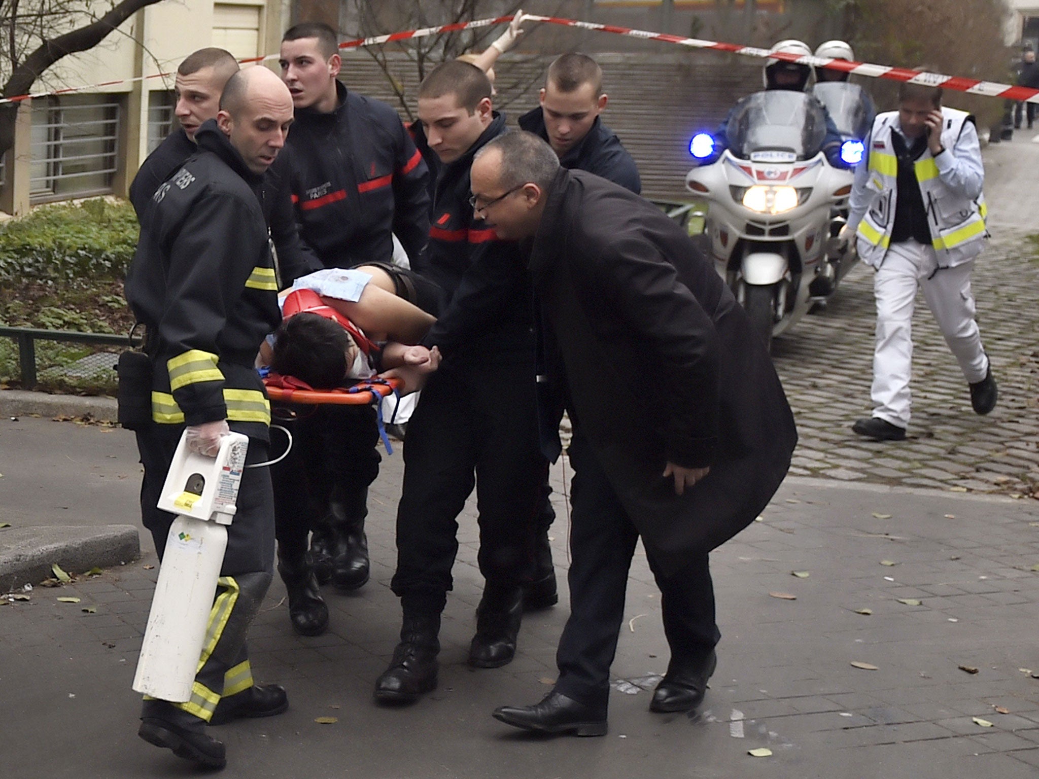 A victim is evacuated on a stretcher after armed gunmen stormed the offices of the French satirical newspaper Charlie Hebdo in Paris