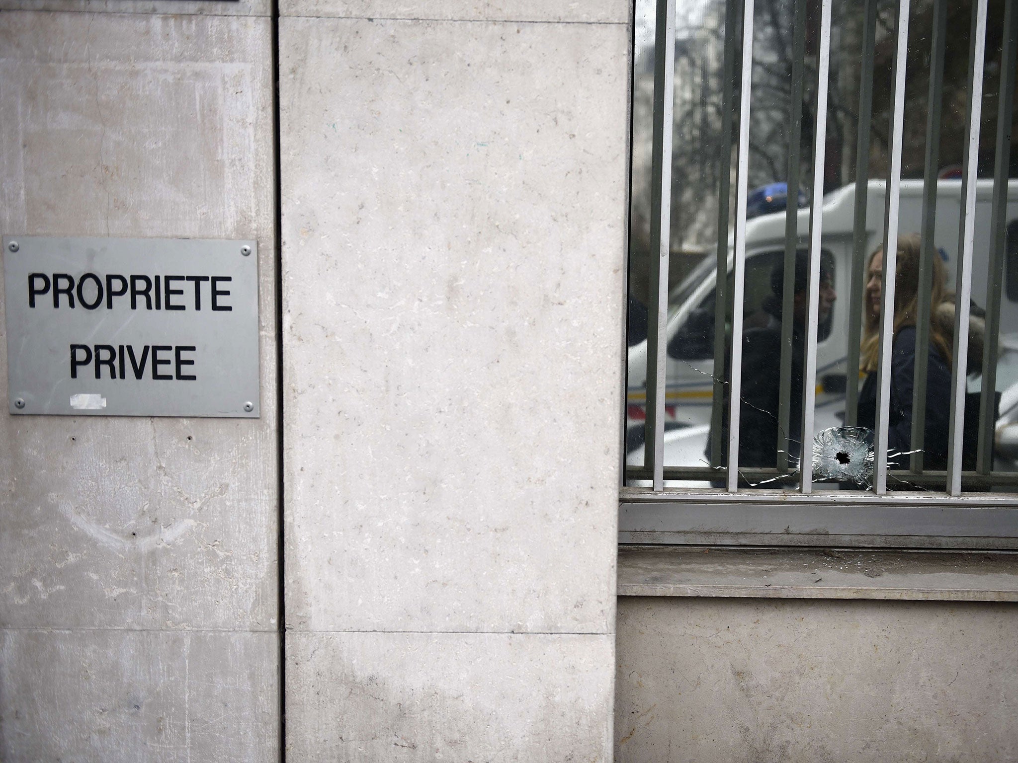 A bullet's impact on the window of the offices of the French satirical newspaper Charlie Hebdo in Paris, after armed gunmen stormed the offices leaving at least 10 people dead
