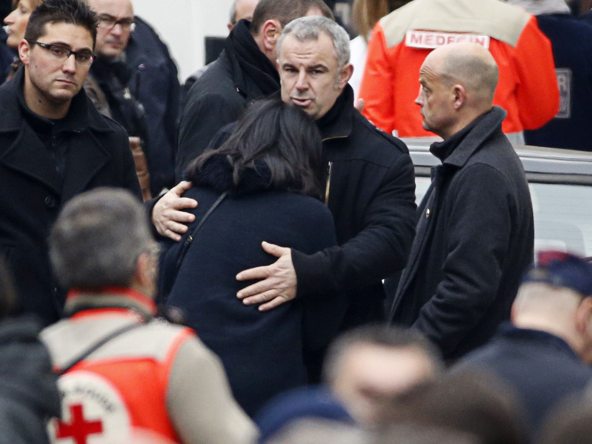 French former Youth and Associations Junior minister Jeannette Bougrab (C) is comforted by an unidentified person outside of the headquarters of the French satirical newspaper Charlie Hebdo in Paris