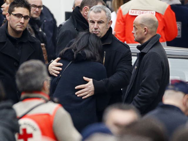 French former Youth and Associations Junior minister Jeannette Bougrab (C) is comforted by an unidentified person outside of the headquarters of the French satirical newspaper Charlie Hebdo in Paris 