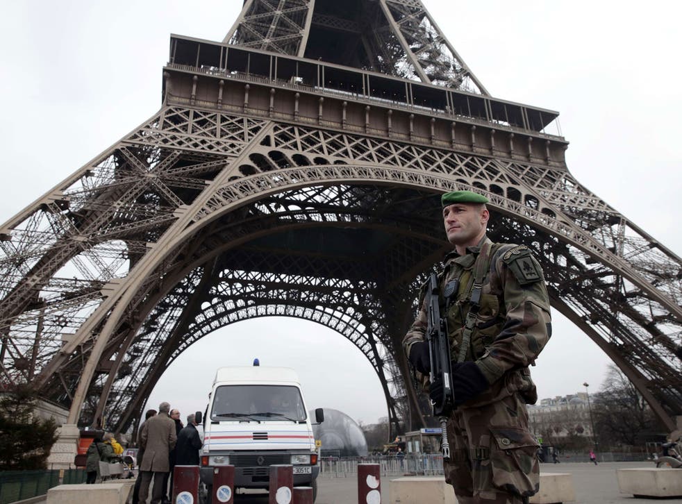 French soldiers patrol in front of the Eiffel Tower in Paris as the capital was placed under the highest alert status after heavily armed gunmen stormed French satirical newspaper Charlie Hebdo and shot dead at least 12 people in the deadliest attack in F
