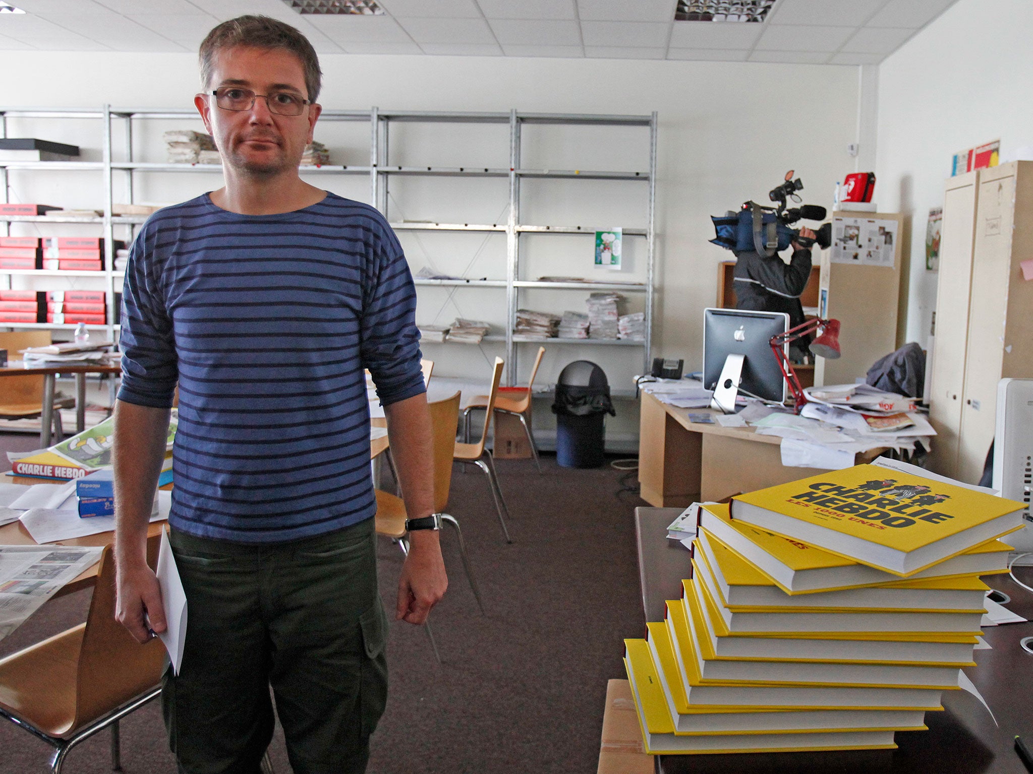 French cartoonist Charb, publishing director of French satirical weekly Charlie Hebdo, poses for photographs at their offices in Paris, September 19, 2012
