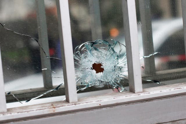 A bullet impact is seen in a window of a building next to the French satirical newspaper Charlie Hebdo's office, in Paris
