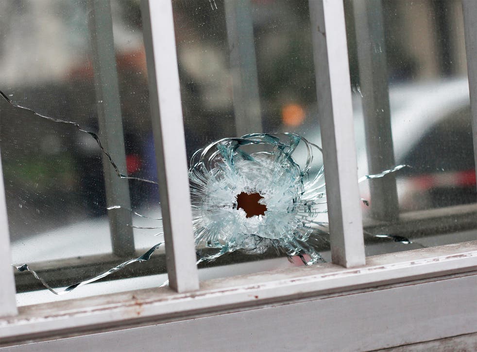 A bullet impact is seen in a window of a building next to the French satirical newspaper Charlie Hebdo's office, in Paris