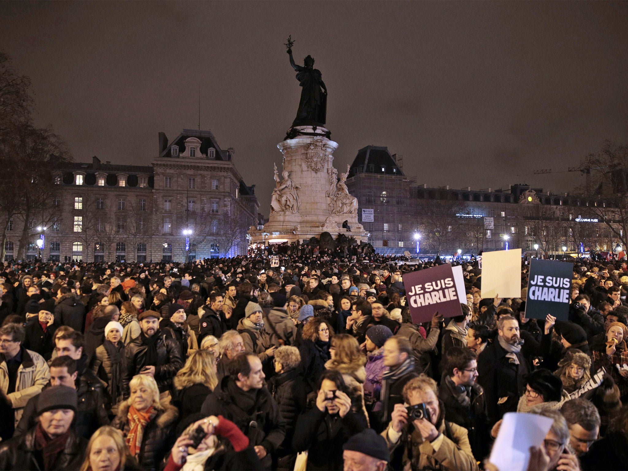 People hold placards reading in French 'I am Charlie' during a gathering at the Place de la Republique in Paris