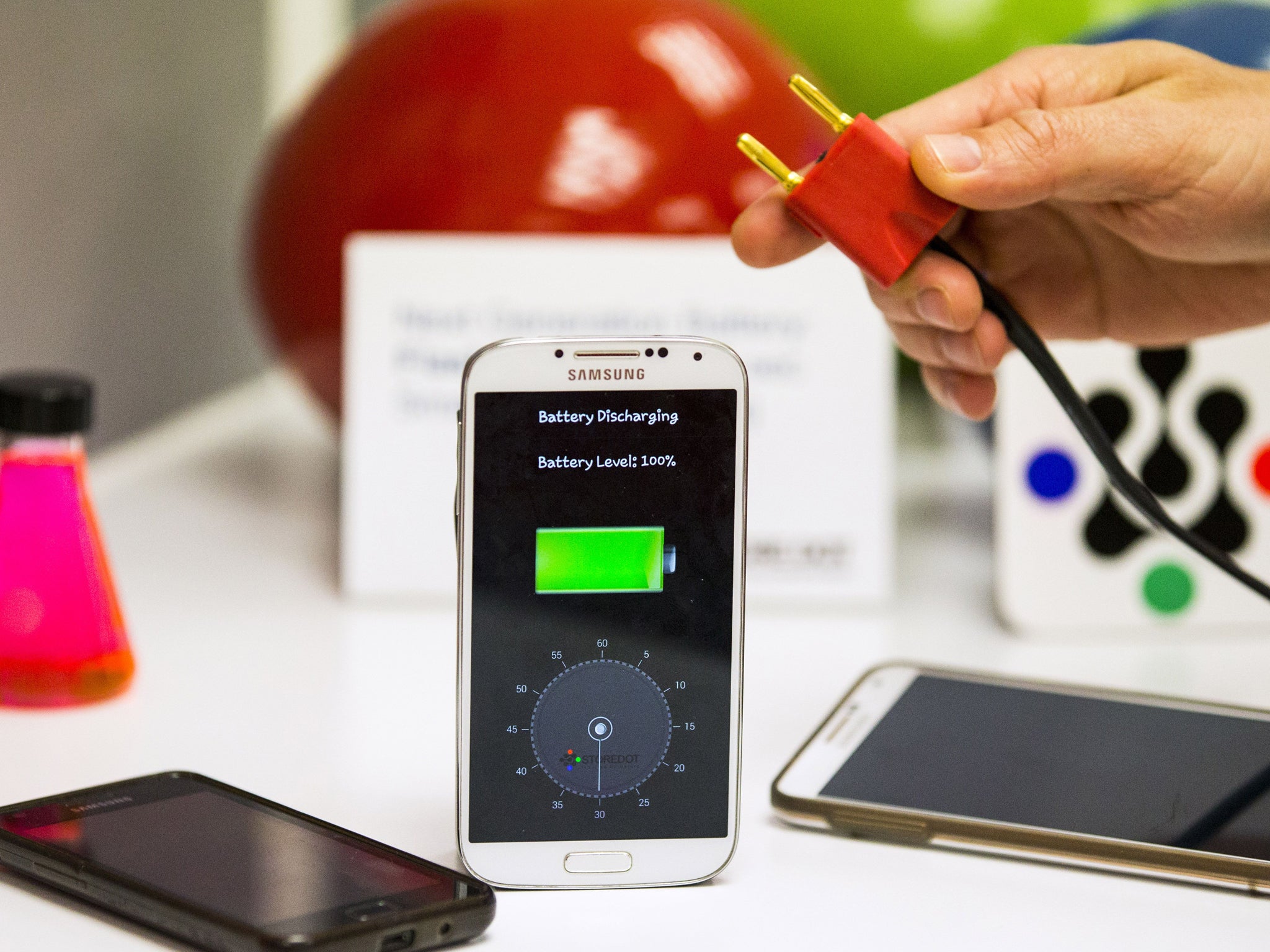 A member of the Israeli startup StoreDot demonstrates a bio-organic charger system which they are developing that can recharge a smartphone battery in just 30 seconds at their laboratory in the Tel Aviv on April 9, 2014