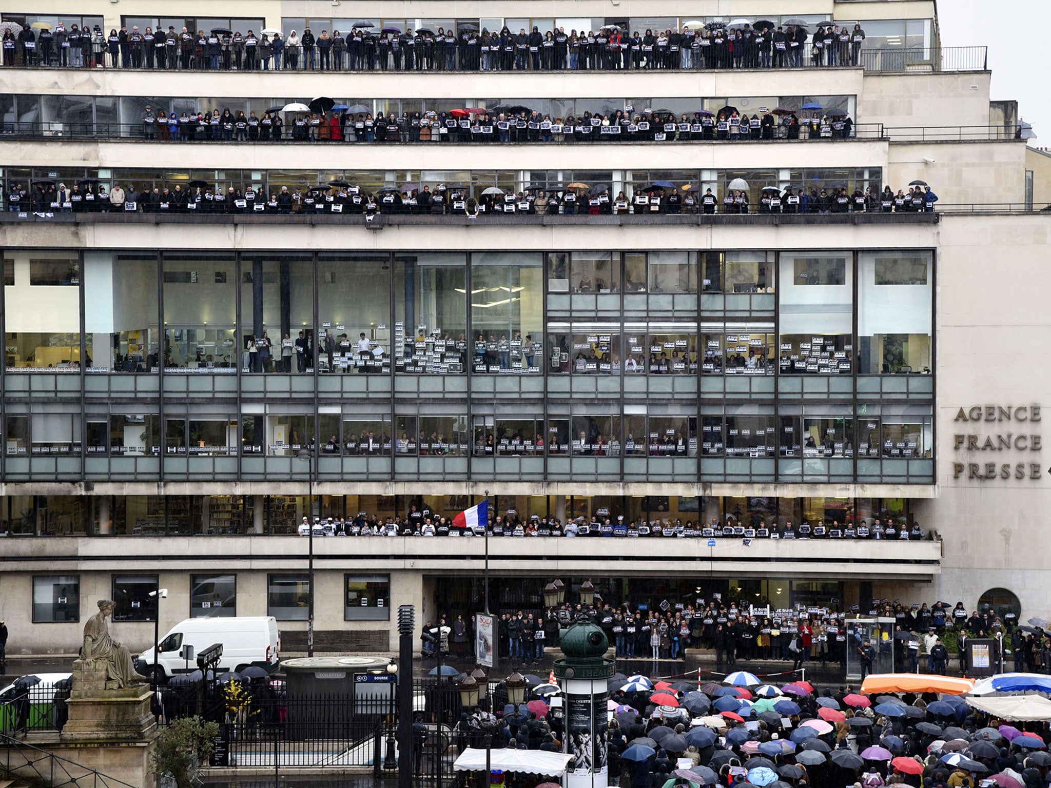 Journalists of international press agency Agence France-Presse (AFP) hold signs reading "Je suis Charlie" (I am Charlie) at their headquarters in Paris as they observe a minute of silence for the victims of an attack by armed gunmen on the offices of Fren
