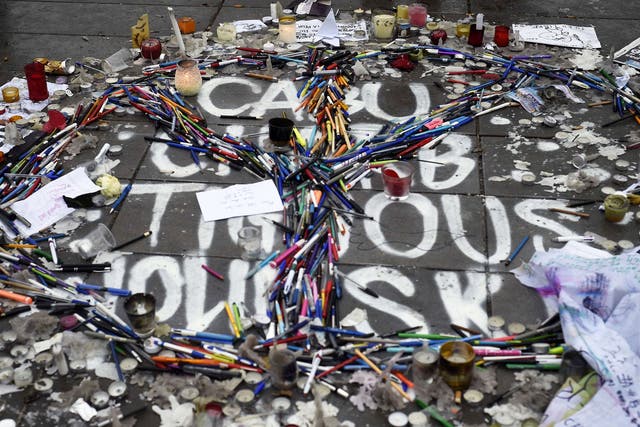 Pens and pencils are placed in the form of a peace sign over the names of late French cartoonists Cabu, Tignous, Wolinski and late Charlie Hebdo editor Charb on the Place de la Republique (Republic Square) in Paris 
