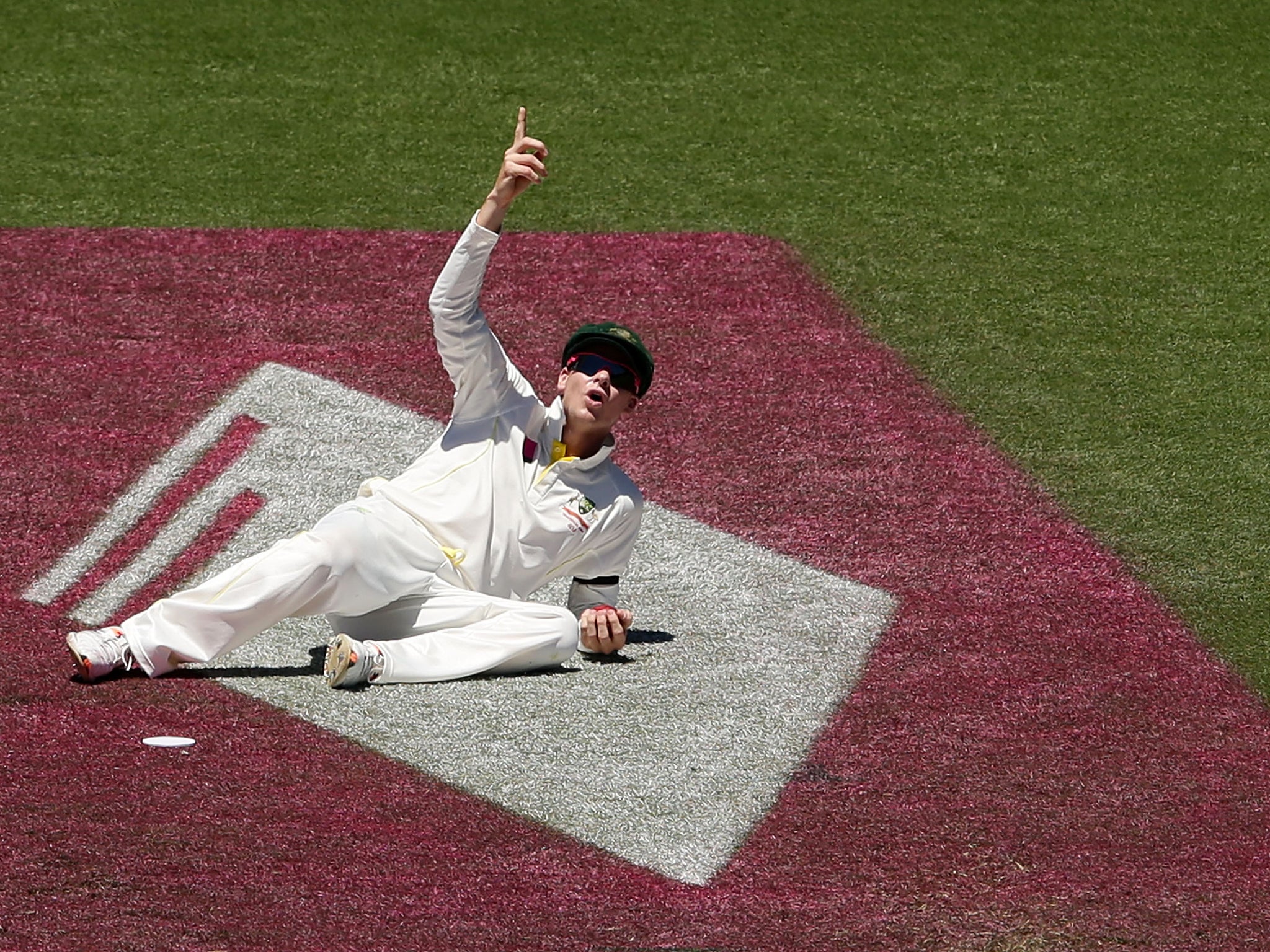 Steve Smith points to the Spidercam after dropping a catch