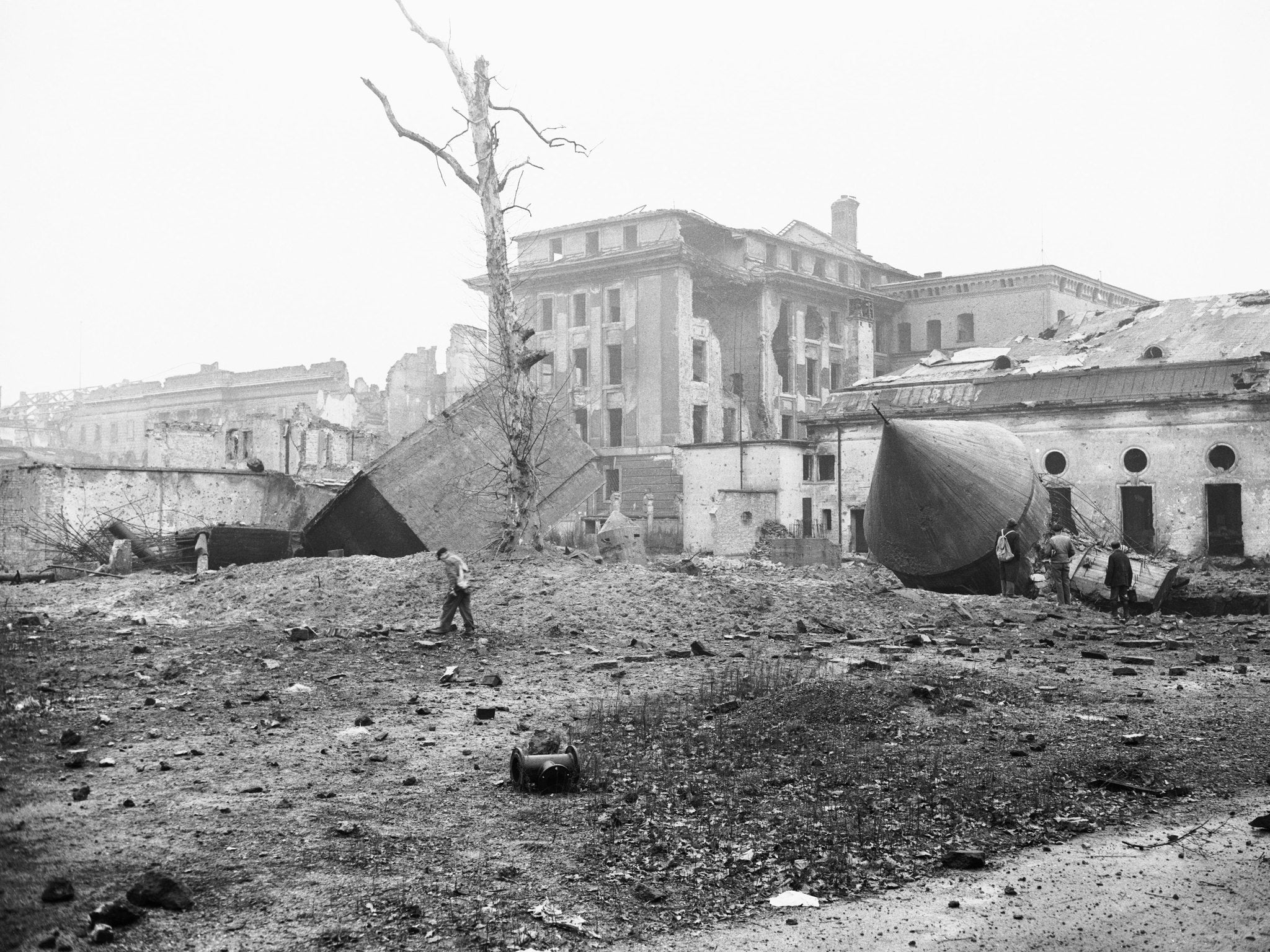 Russians Blow up Hitler's "Tombstone." Berlin, Germany: Sightseers walk amid the ruins of Hitler's air raid shelter, sometimes referred to as Hitler's "tombstone".
