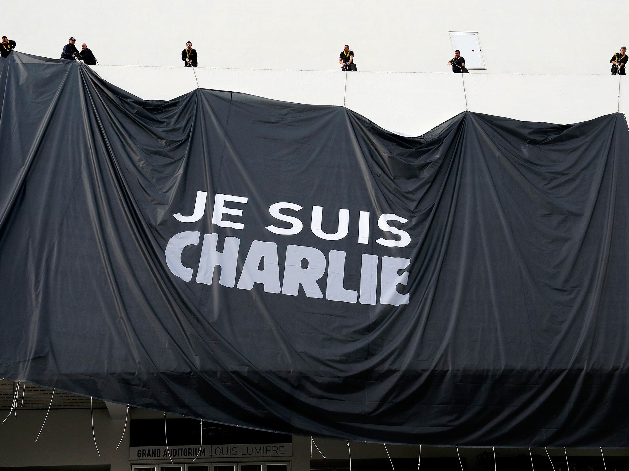Workers install a poster reading 'Je suis Charlie' (I am Charlie) on the Palais des Festivals facade in Cannes