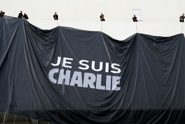 Workers install a poster reading 'Je suis Charlie' (I am Charlie) on the Palais des Festivals facade in Cannes 