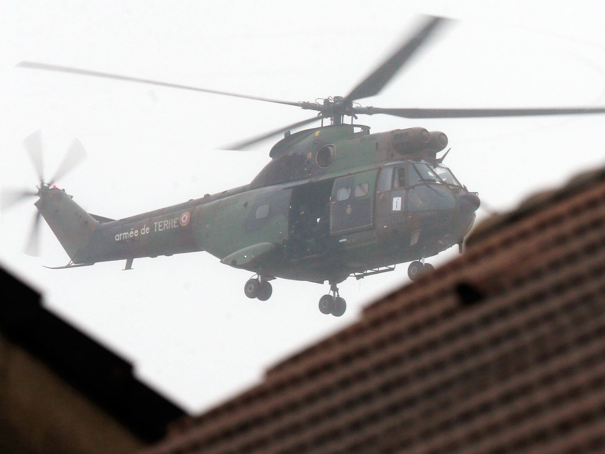 A French Army helicopter with intervention forces hovers near the scene of a hostage taking at an industrial zone in Dammartin-en-Goele, northeast of Paris