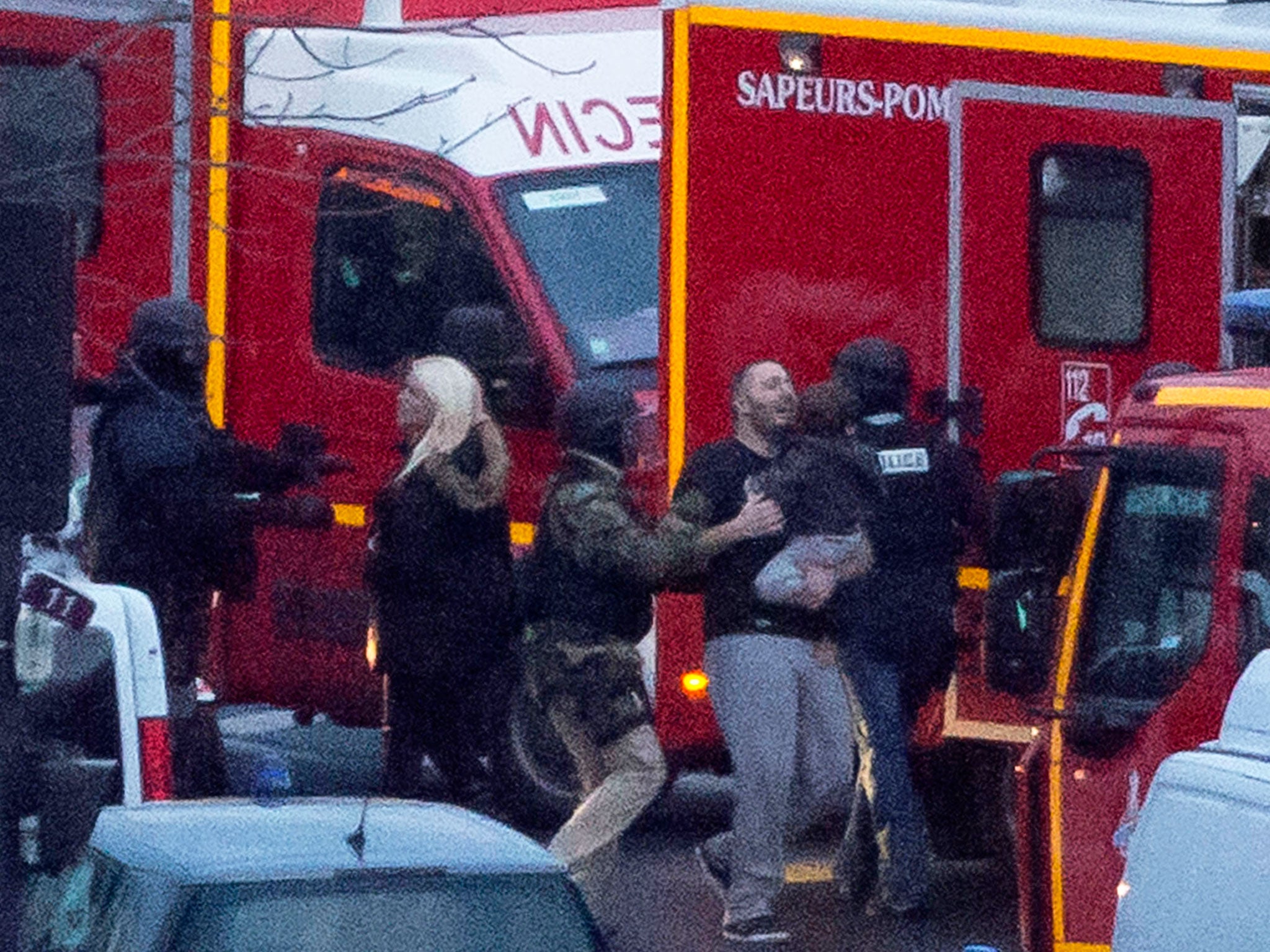 A security officer directs released hostages after they stormed a kosher market to end a hostage situation