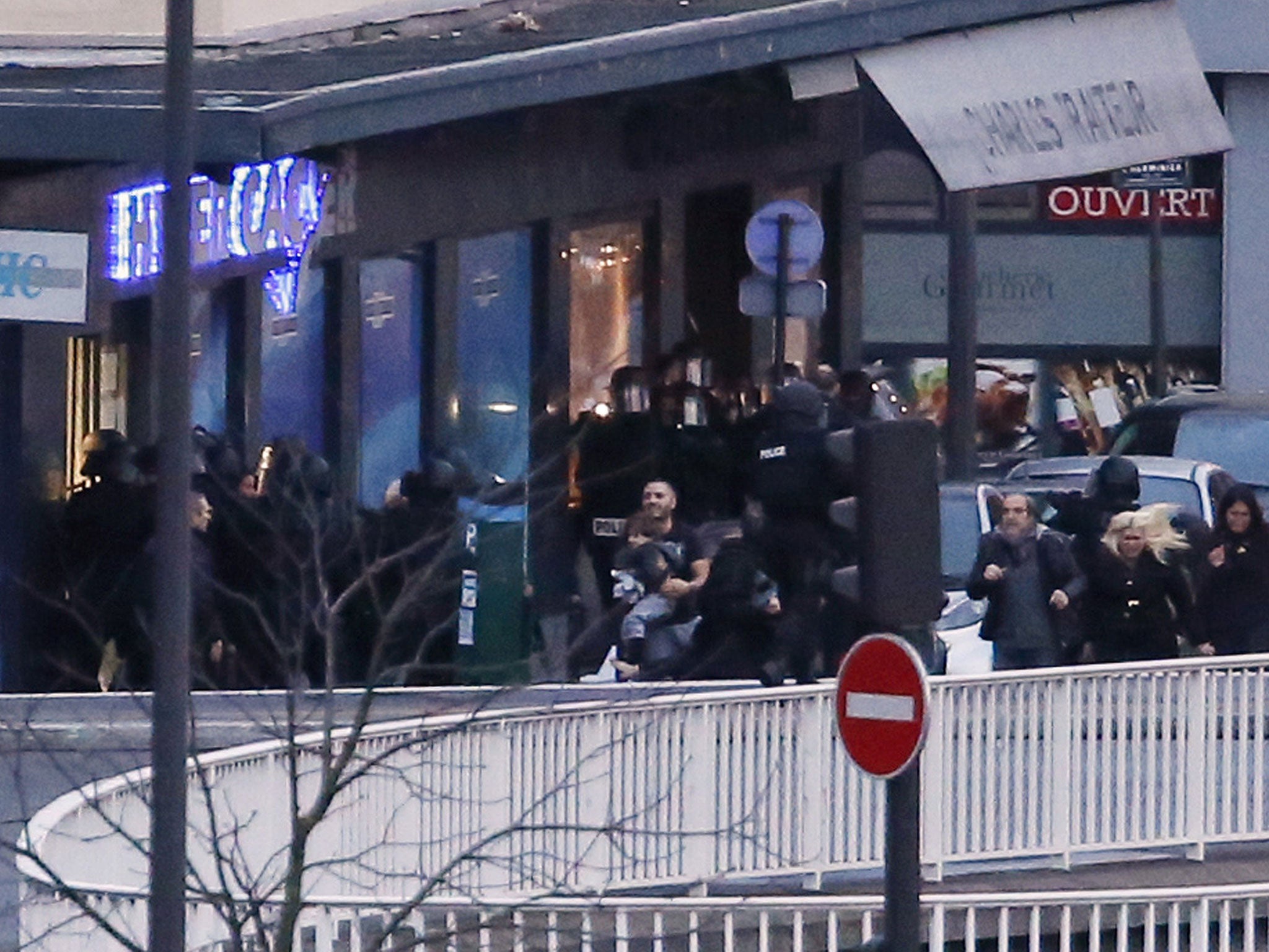 Members of the French police special forces evacuate the hostages including a child (C) after launching the assault at a kosher grocery store in Porte de Vincennes, eastern Paris