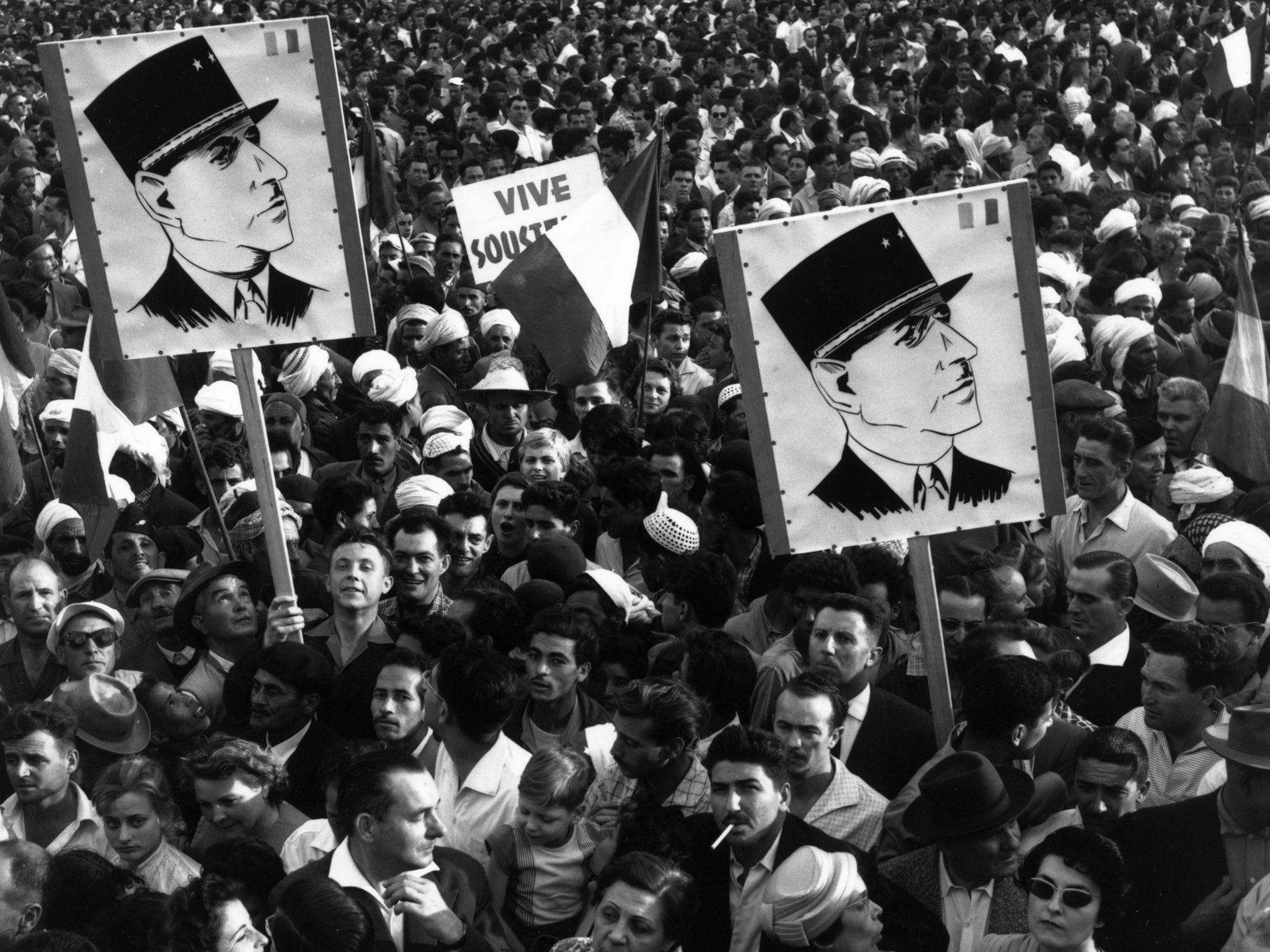 A crowd of Algerian demonstrators outside Government House, carrying Charles de Gaulle posters during the Algerian war of independence in 1985