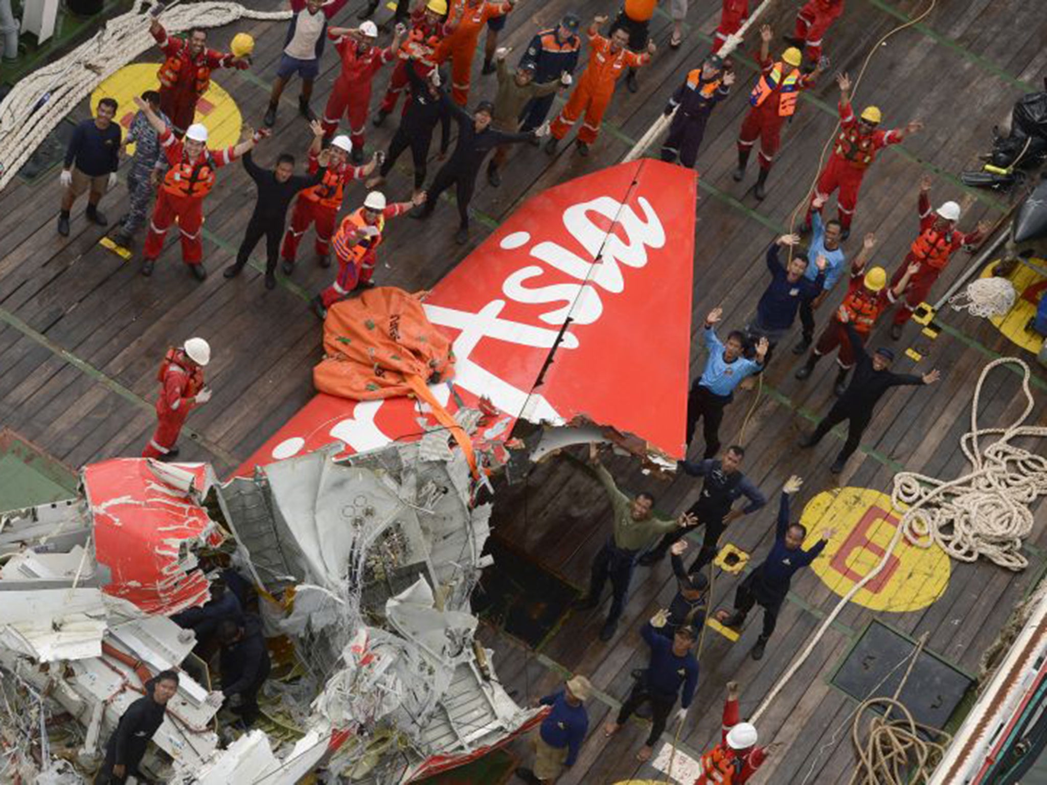 Members of the salvage crew with the tail section of the AirAsia jet liner (AP)