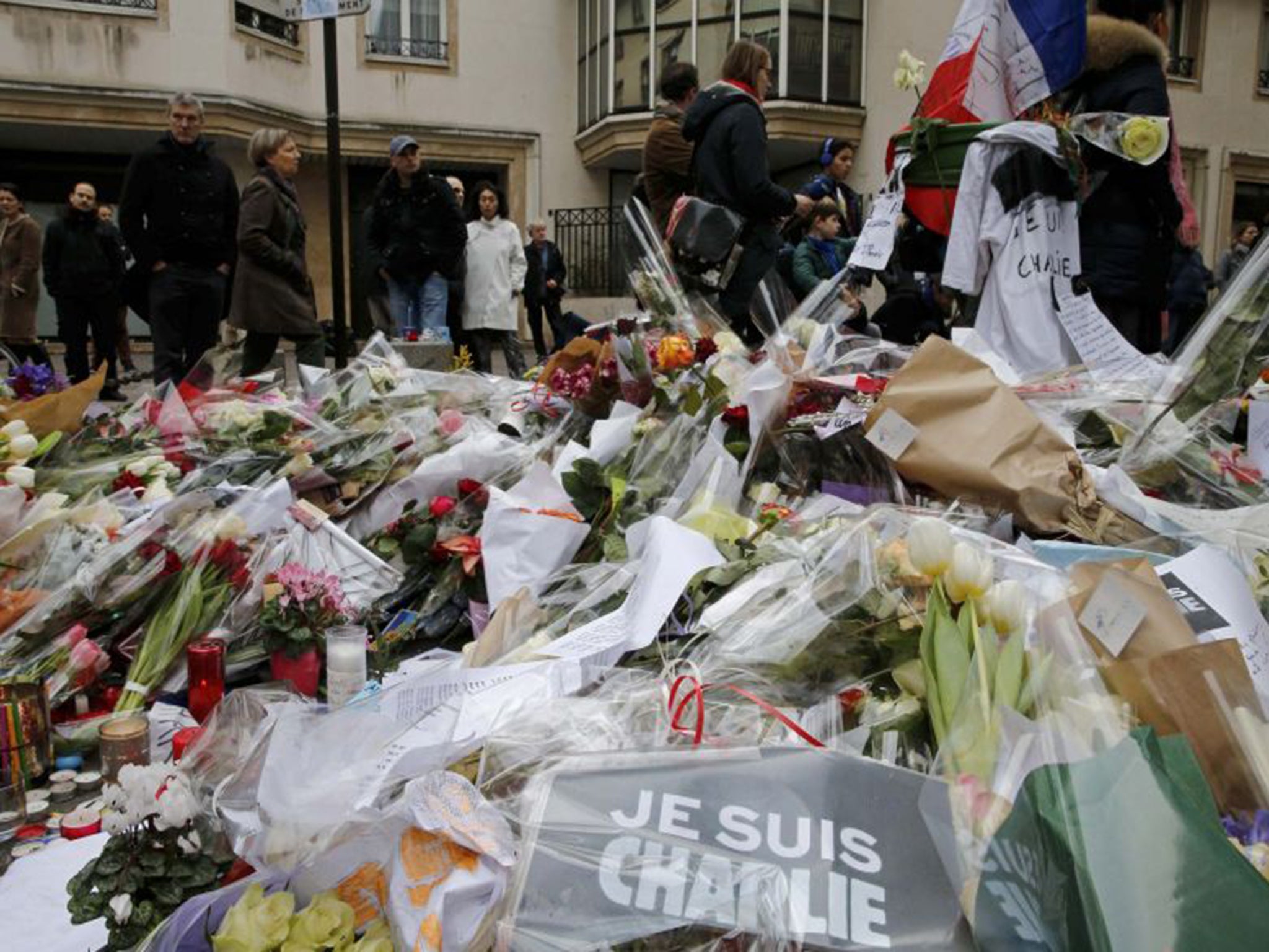 Flowers and messages lie in tribute in front of the offices of the weekly satirical newspaper Charlie Hebdo on Saturday (Reuters)