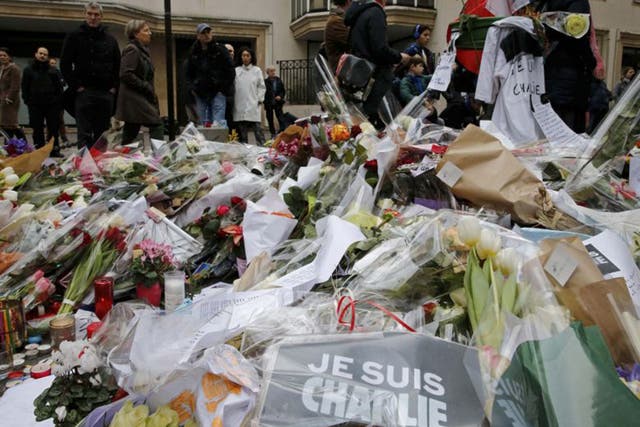 Flowers and messages lie in tribute in front of the offices of the weekly satirical newspaper Charlie Hebdo on Saturday (Reuters)