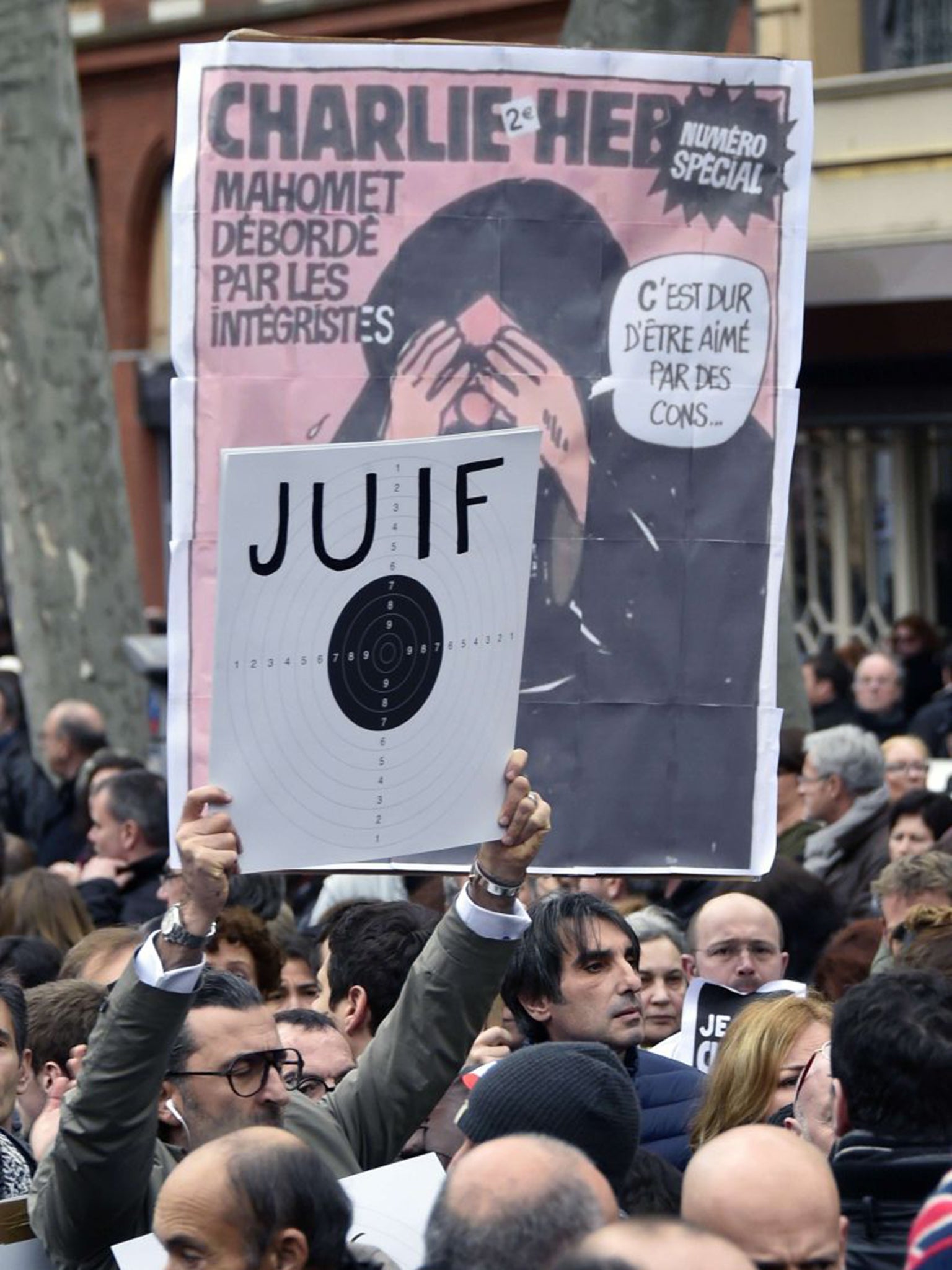 Marchers hold up Charlie Hebdo covers in Toulouse on Saturday