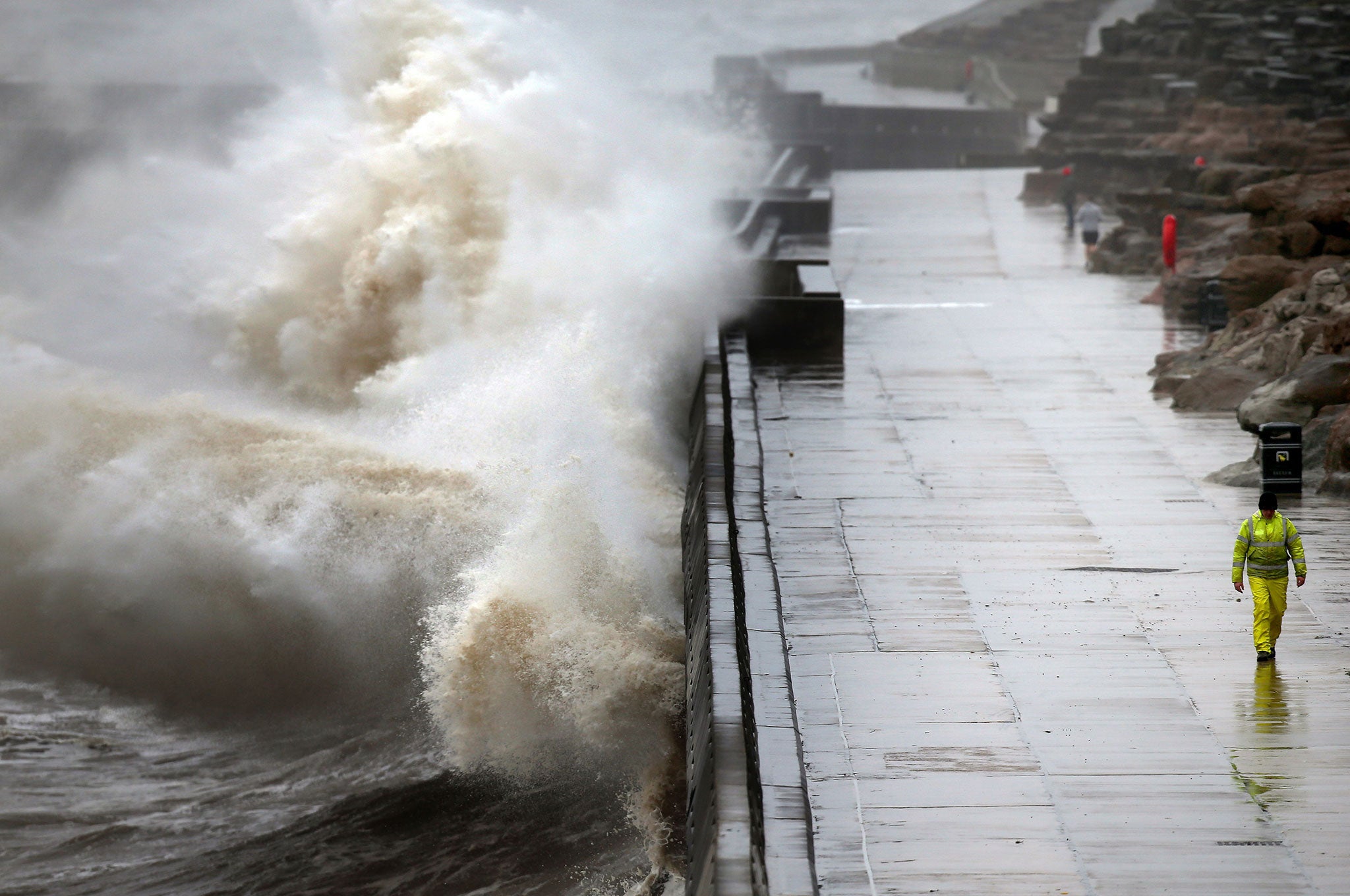 Waves crash against the sea walls in Blackpool, England as high winds batter the north of the country