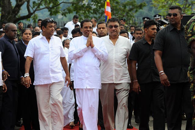 Sri Lanka’s new President Maithripala Sirisena, centre, arrives to address the nation from outside the Buddhist Temple of the Tooth in Kandy, after defeating Mahinda Rajapaksa