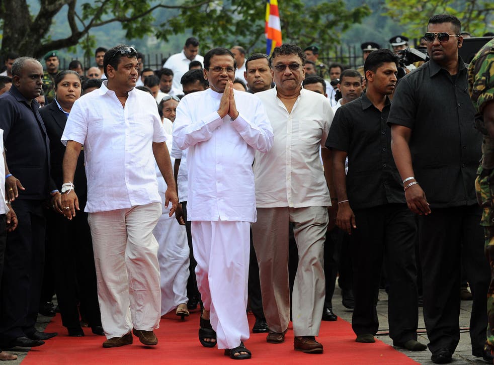 Sri Lanka’s new President Maithripala Sirisena, centre, arrives to address the nation from outside the Buddhist Temple of the Tooth in Kandy, after defeating Mahinda Rajapaksa