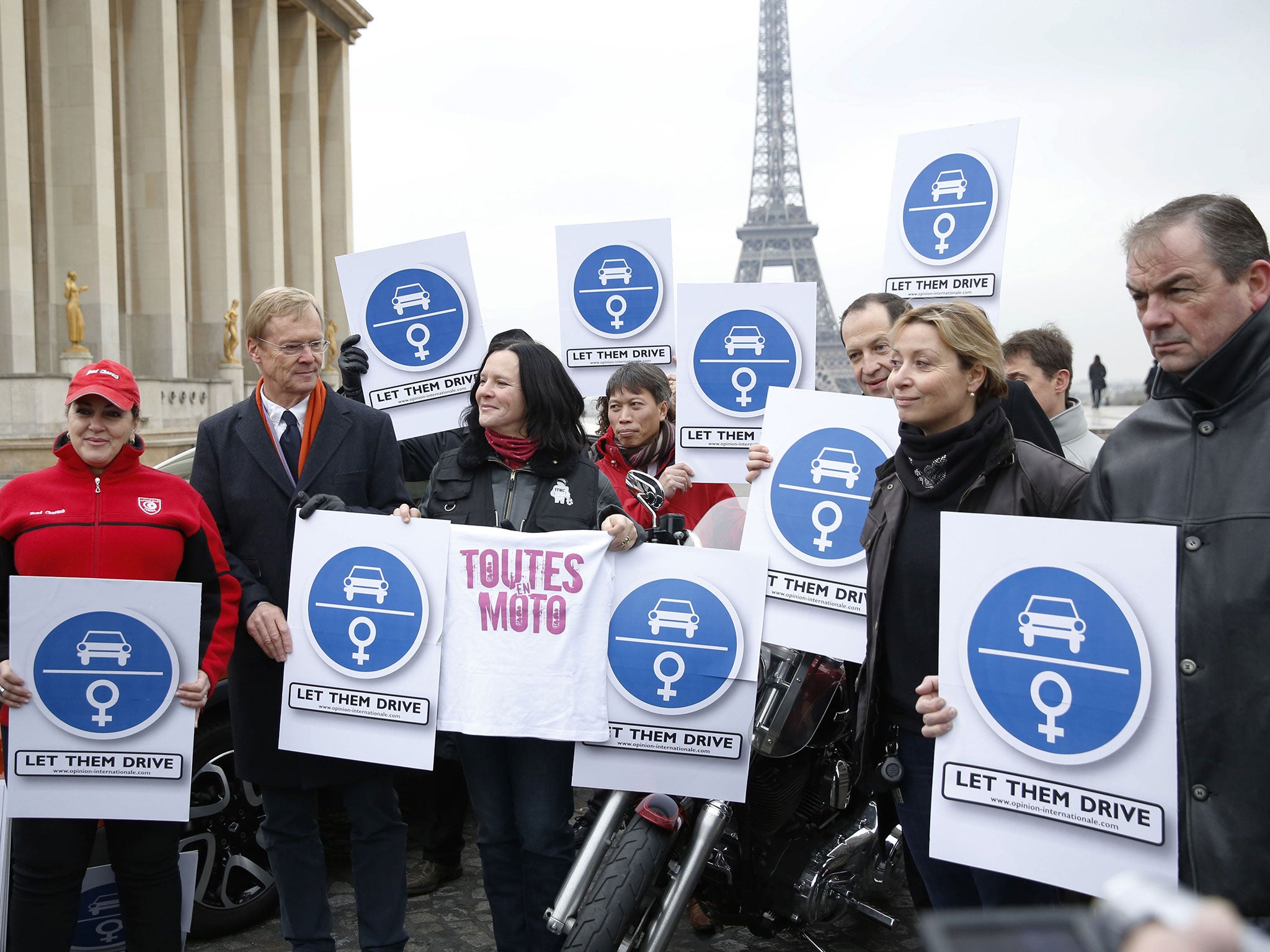 Former rally driver Ari Vatanen, 2nd left, and Tunisian driver Hend Chaouch, left, take part in a demonstration to support Saudi women's right to drive in 2013, Paris