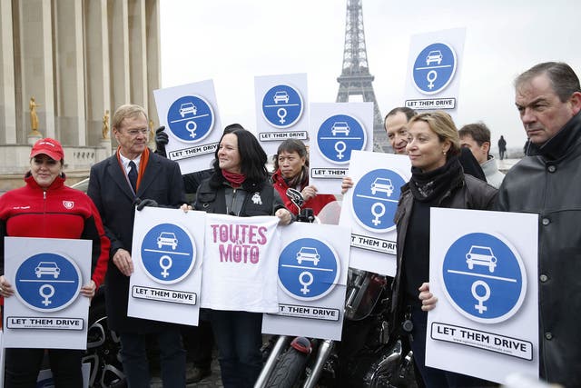 Former rally driver Ari Vatanen, 2nd left, and Tunisian driver Hend Chaouch, left, take part in a demonstration to support Saudi women's right to drive in 2013, Paris