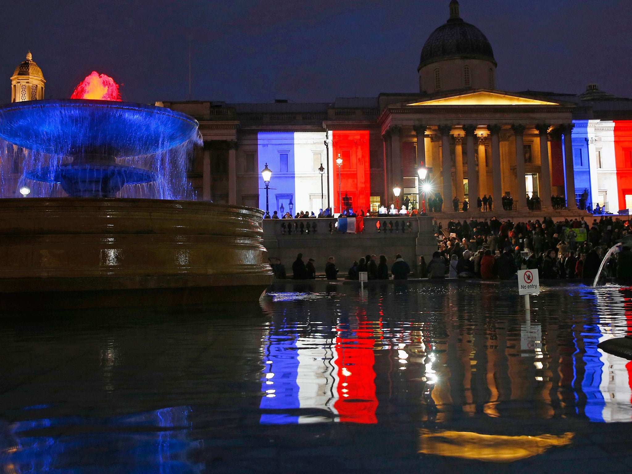 The colours of the French national flag are reflected in the fountains of Trafalgar Square as they are projected in tribute to the Paris terror attacks, on the The National Gallery in London