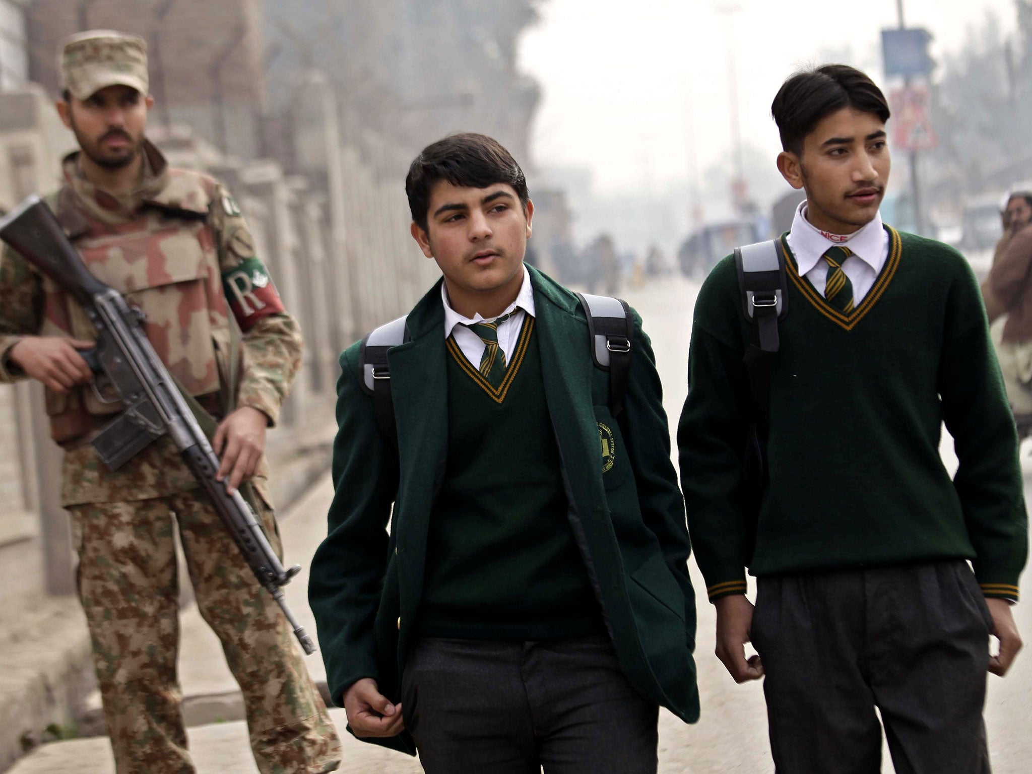 Pakistani school children leave the Army Public School after it was reopened following an attack by Taliban militants, in Peshawar