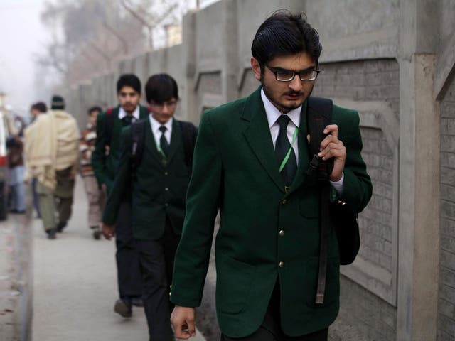 Schoolchildren arrive at the Army Public School on 12 January, 2015, after it was reopened following an attack by Taliban militants, in Peshawar, Pakistan