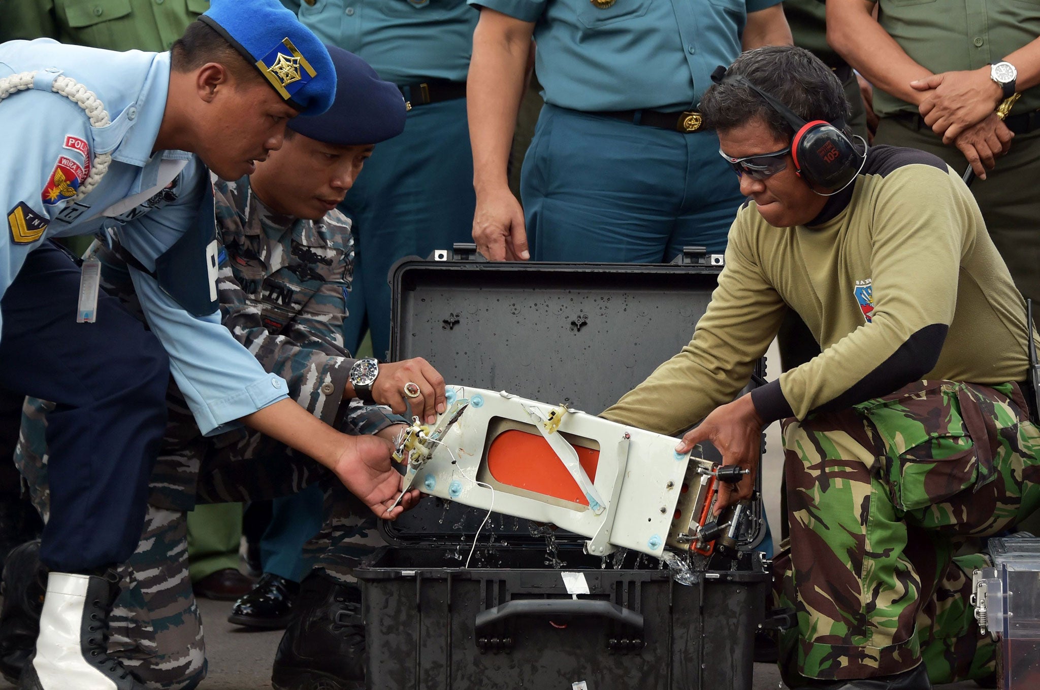 The flight data recorder of AirAsia QZ8501 is lifted out of a carrying case at the airbase in Pangkalan Bun, Central Kalimantan