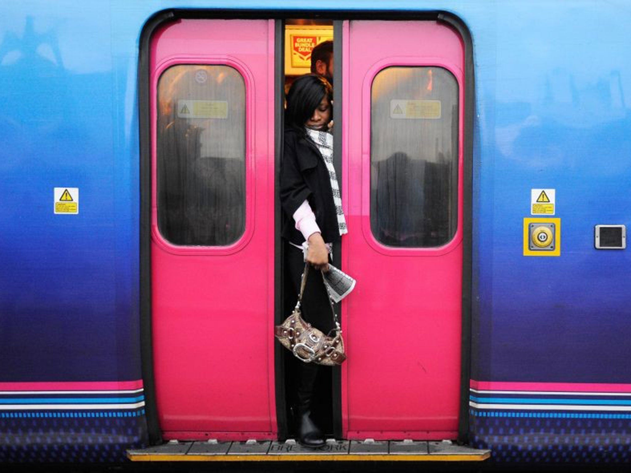 A commuter struggles to get on a train due to the bus strike in London