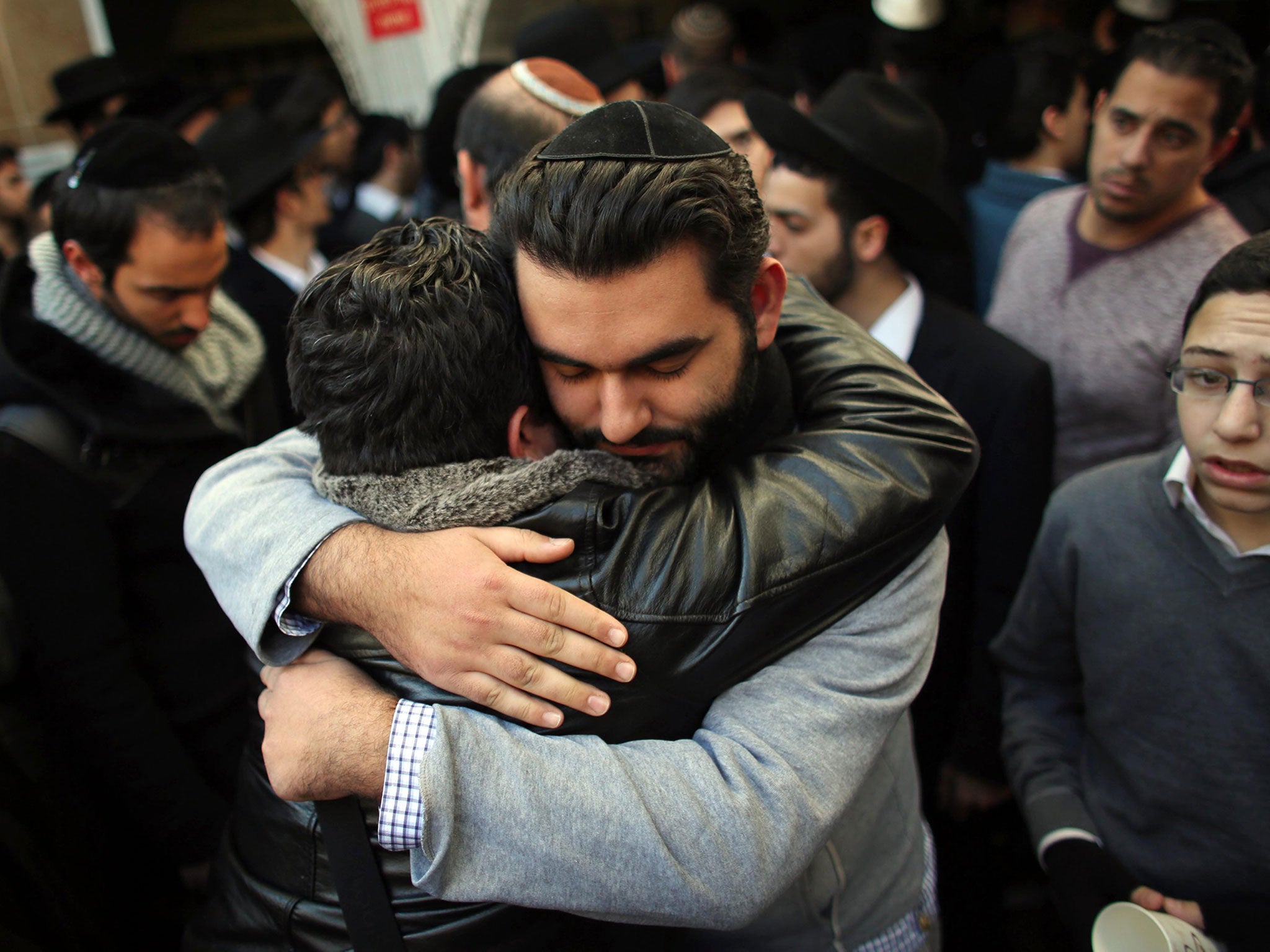 Relatives of Yoav Hattab comfort each other as they gather for the start of the funeral ceremony