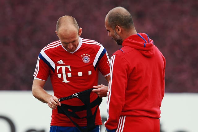 Head coach Pep Guardiola talks to Arjen Robben in Doha