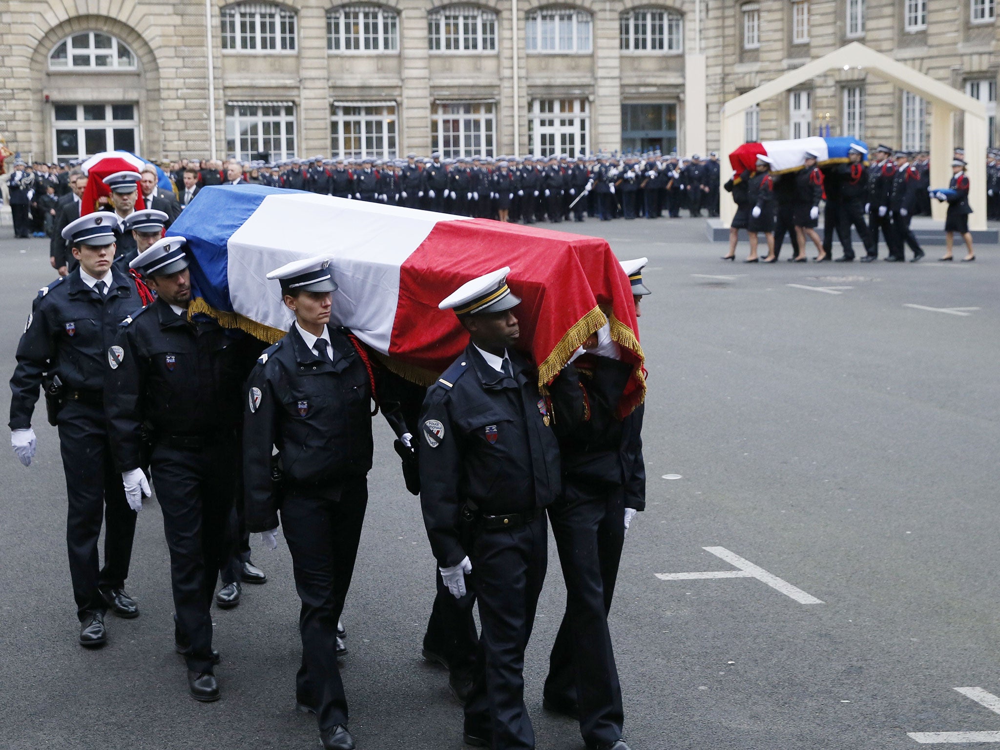 Police officers carry the coffins draped in the French flag of the three Police officers killed in the recent Islamist attacks