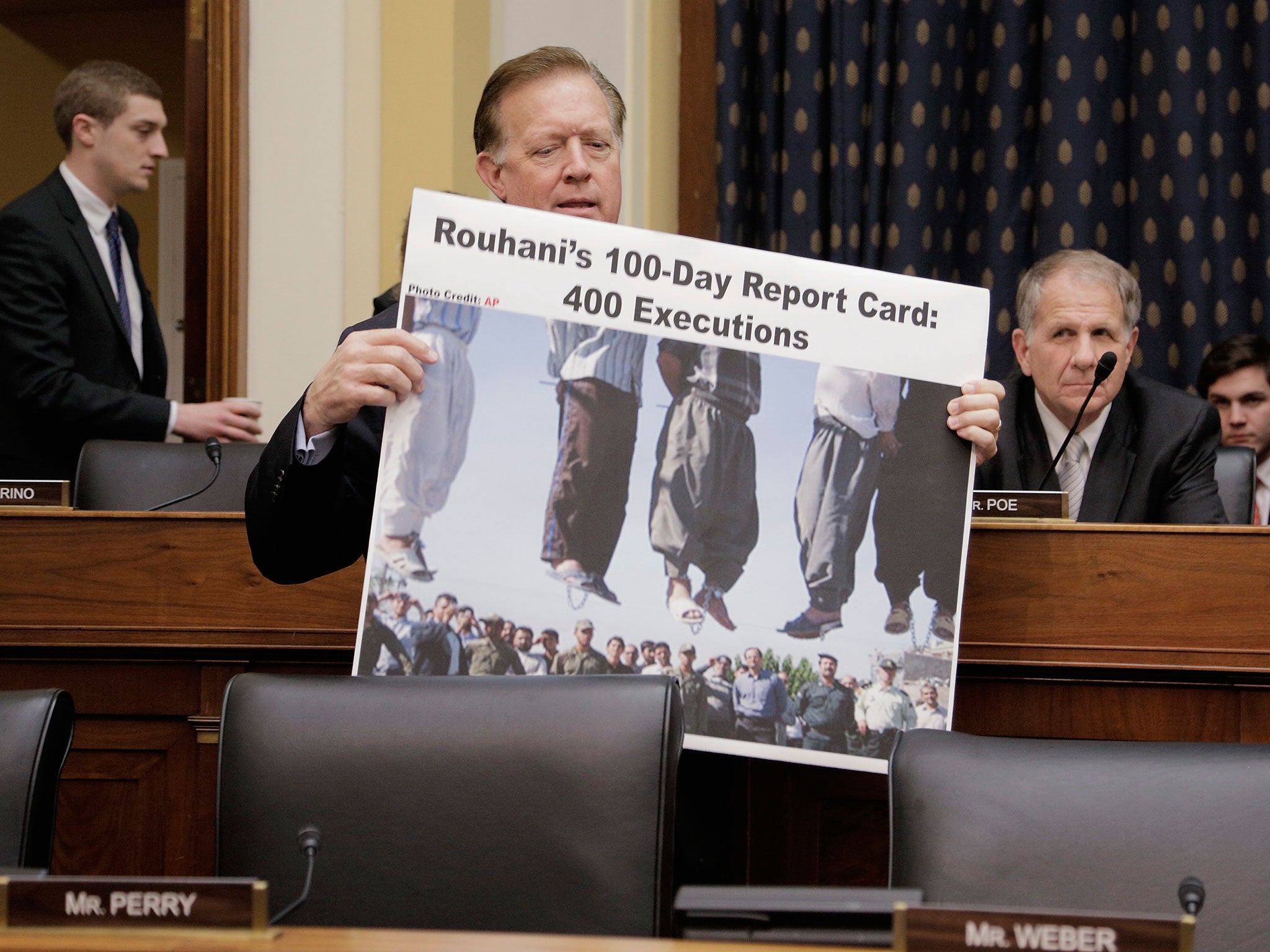 Randy Weber carrying a poster accusing Iranian President Hassan Rouhani of hundreds of executions at a House Foreign Affairs Committee hearing