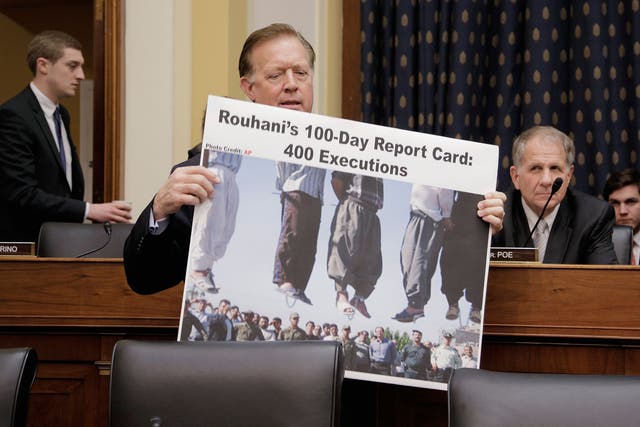 Randy Weber carrying a poster accusing Iranian President Hassan Rouhani of hundreds of executions at a House Foreign Affairs Committee hearing